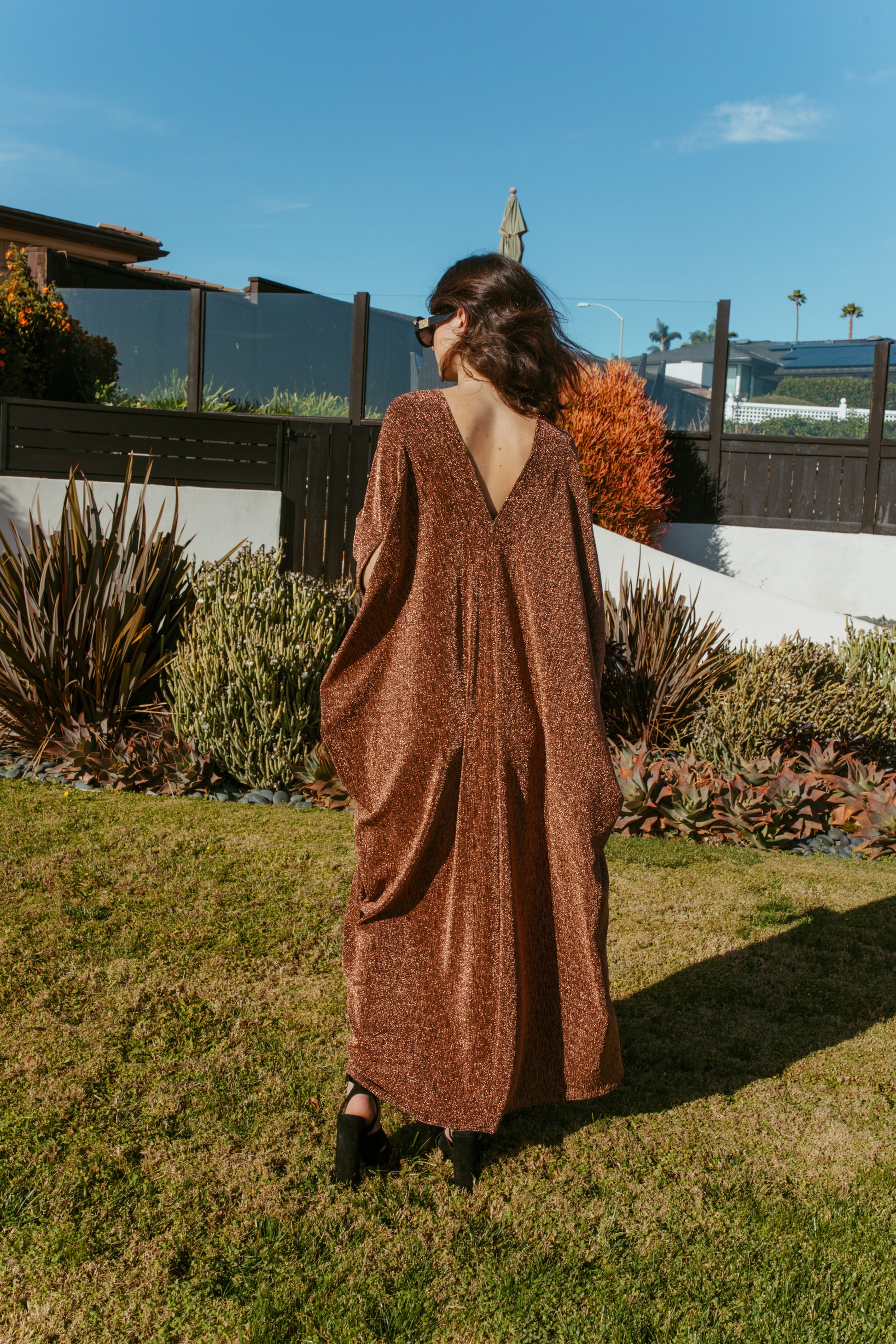 Shimmering, metallic bronze caftan dress featuring v-neck at front and back.