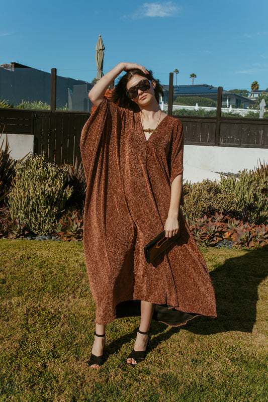 Shimmering, metallic bronze caftan dress featuring v-neck at front and back.