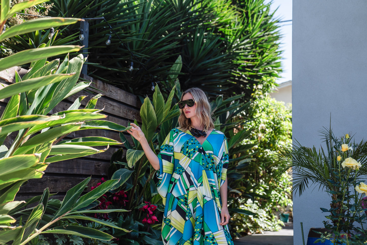 Jennafer Grace caftan in Pucci inspired mosaic print. Featuring an array of blue and green colors, this caftan features a deep v-neck, batwing sleeves, and ankle length hem.  