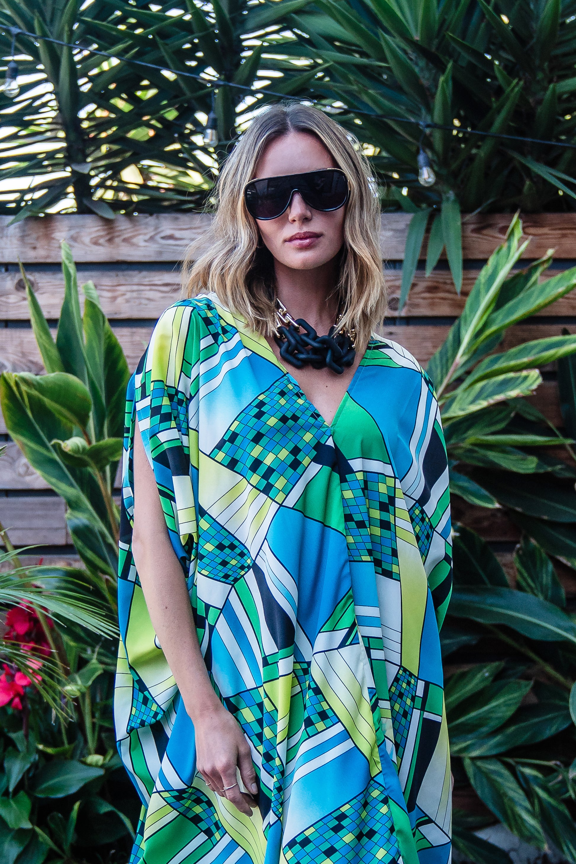 Jennafer Grace caftan in Pucci inspired mosaic print. Featuring an array of blue and green colors, this caftan features a deep v-neck, batwing sleeves, and ankle length hem.  