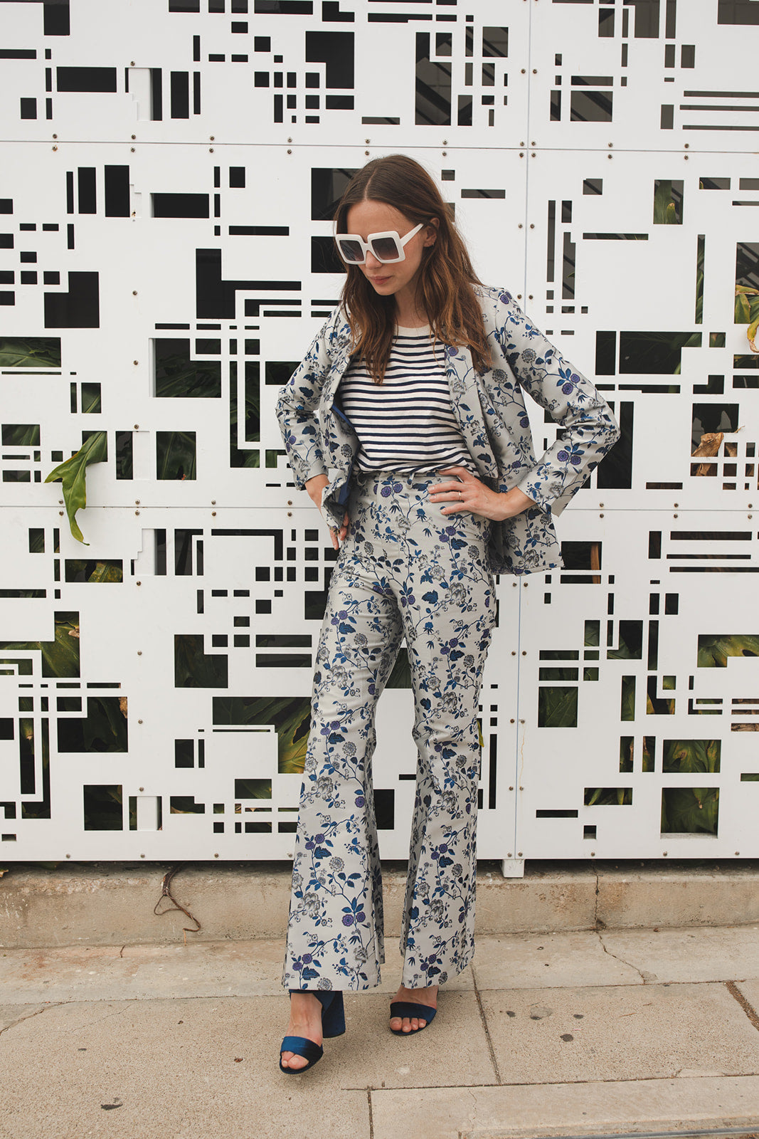 Cool-toned bellbottom pants with a silver and blue floral print. Retro 70's inspired cut with high waist and ankle length hem.