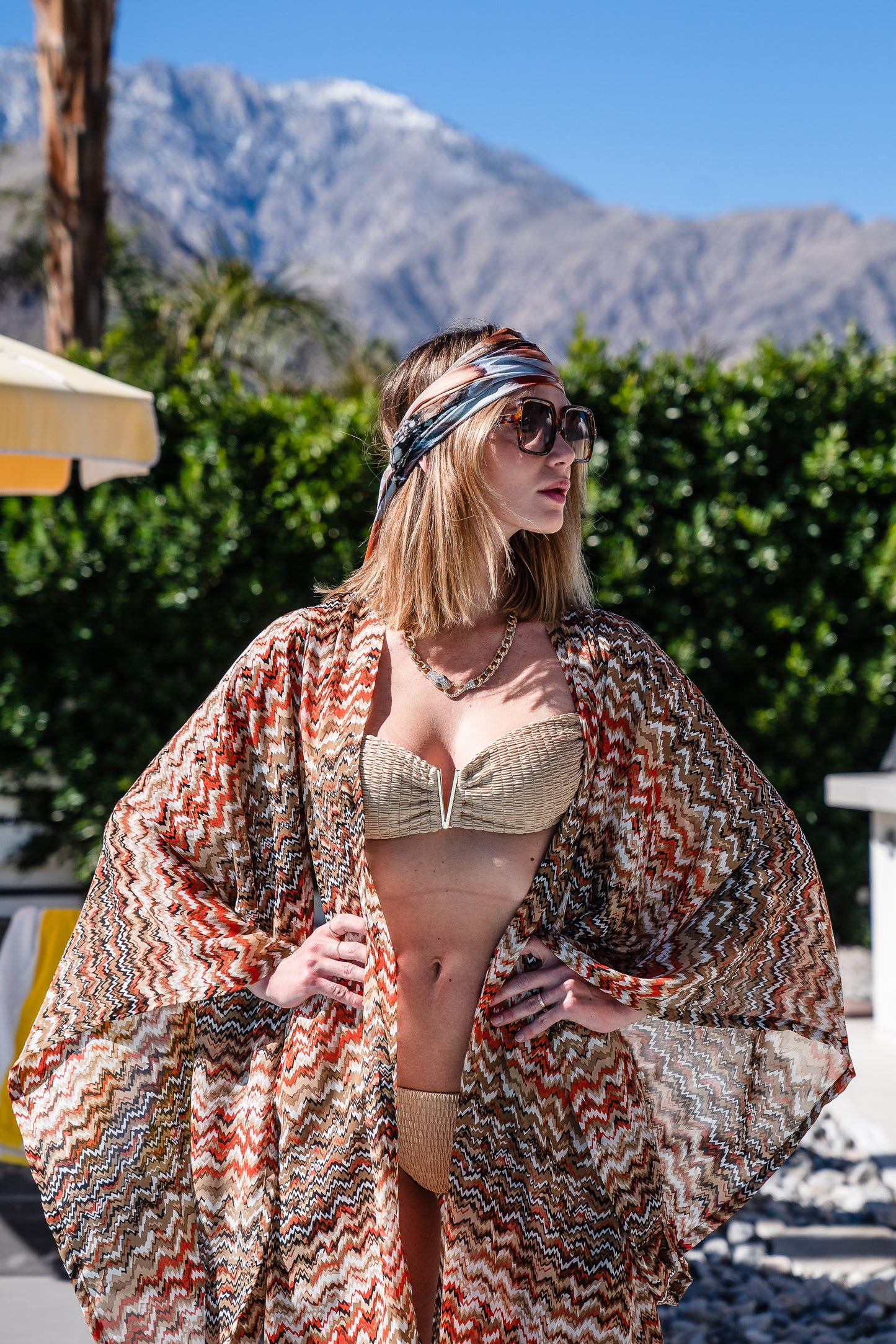 A multicolor brown abstract kimono. Featuring an abstract zig-zag patter of brown, white, orange, and tan, long flowy sleeves with wrist hem, an open front that can be worn as a duster or wrapped as a dress with optional matching waist belt. 