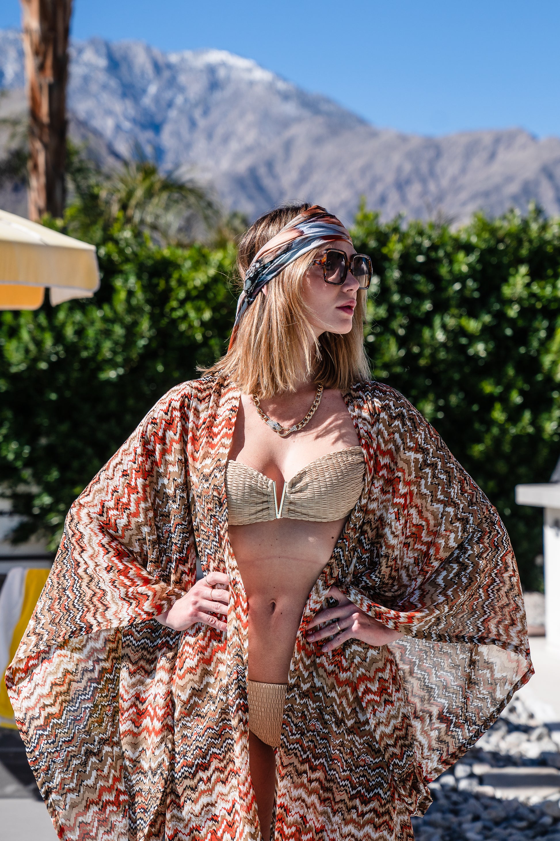 A multicolor brown abstract kimono. Featuring an abstract zig-zag patter of brown, white, orange, and tan, long flowy sleeves with wrist hem, an open front that can be worn as a duster or wrapped as a dress with optional matching waist belt. 