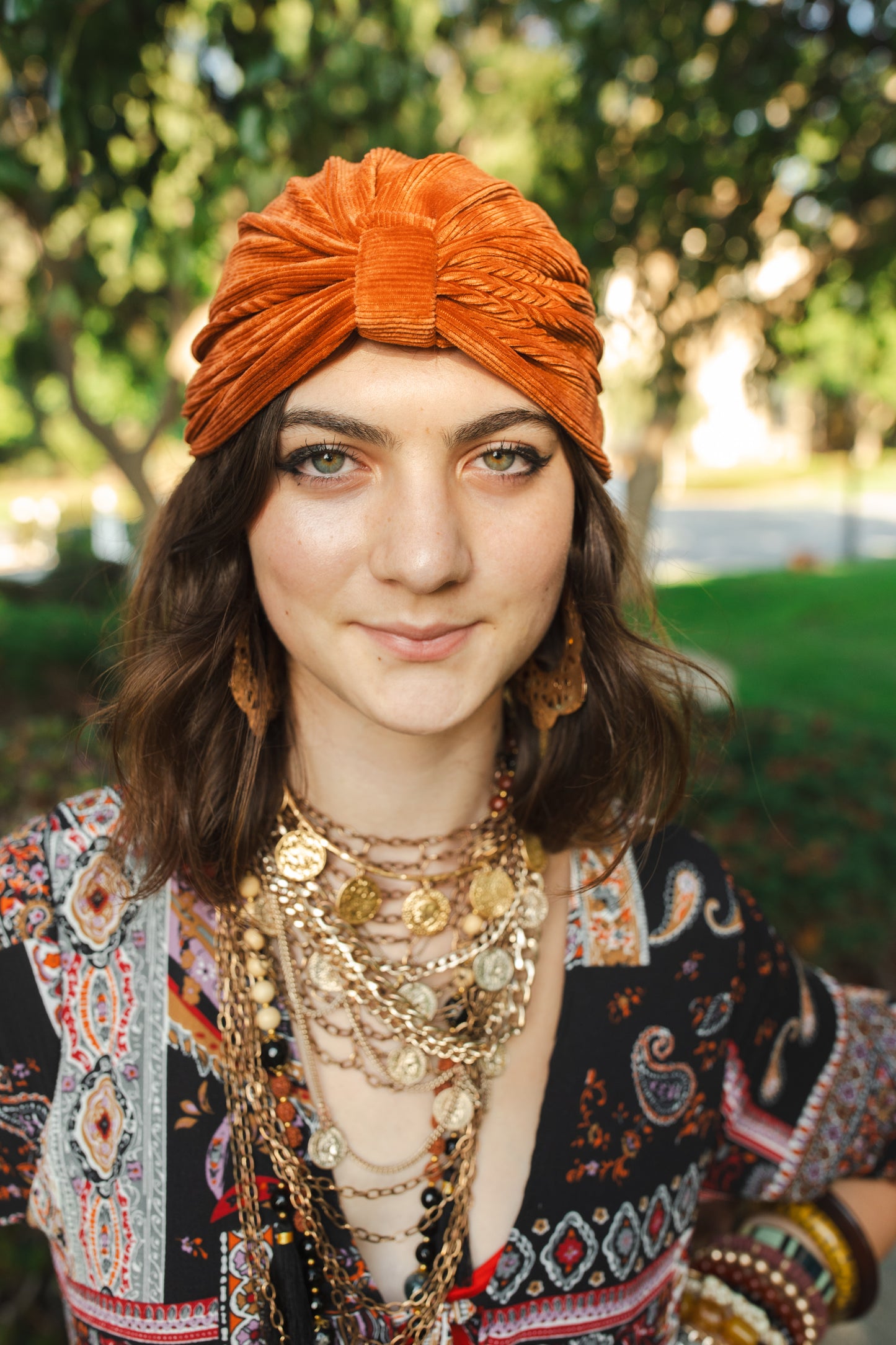 Apricot orange, ribbed stretch velvet fashion turban hat that wears similar to a beanie, with ruching of the fabric that meets front and center at an elegant knot. Vintage-inspired retro 1920s mixed with a modern fabric.