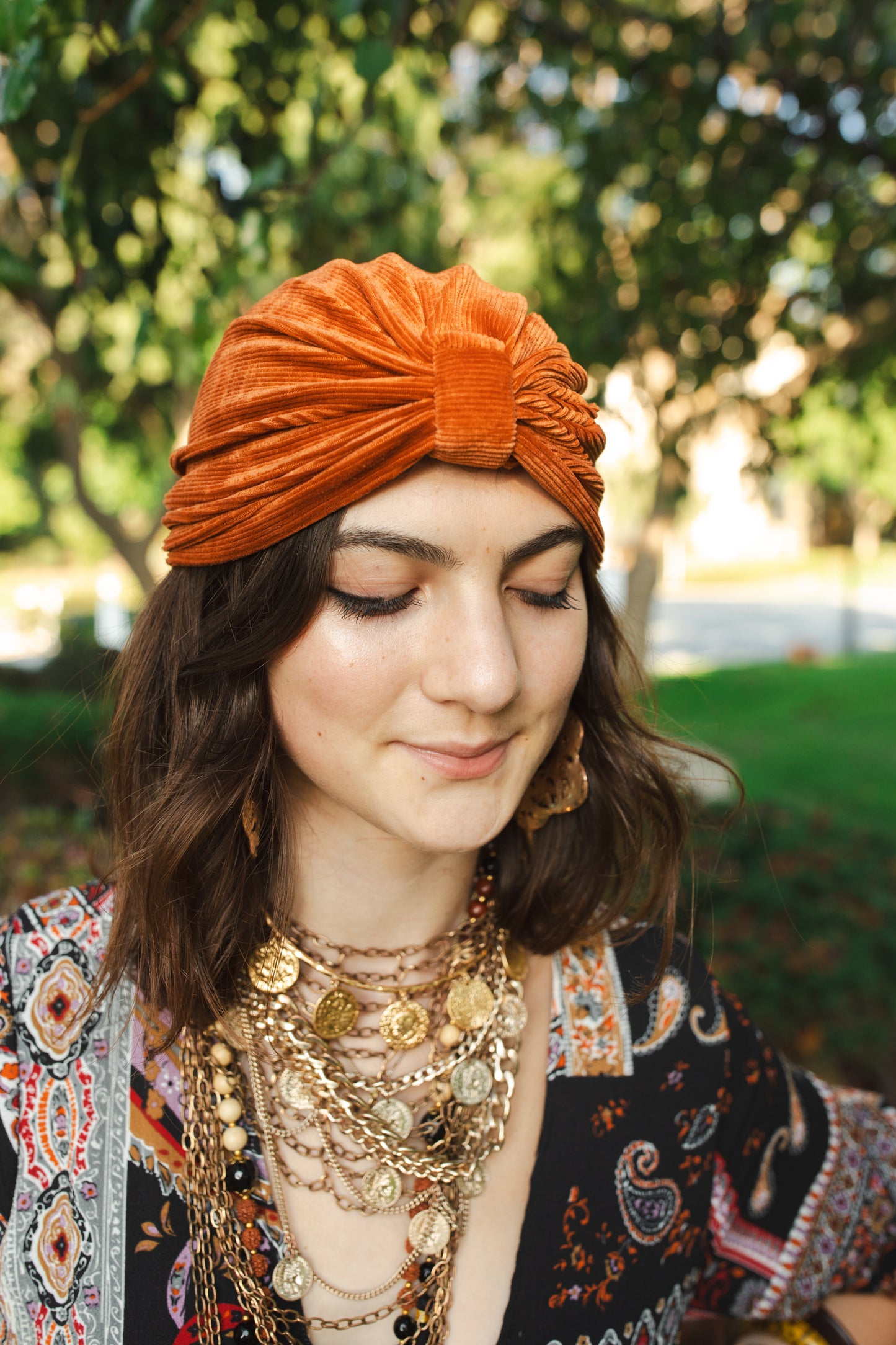 Apricot orange, ribbed stretch velvet fashion turban hat that wears similar to a beanie, with ruching of the fabric that meets front and center at an elegant knot. Vintage-inspired retro 1920s mixed with a modern fabric.
