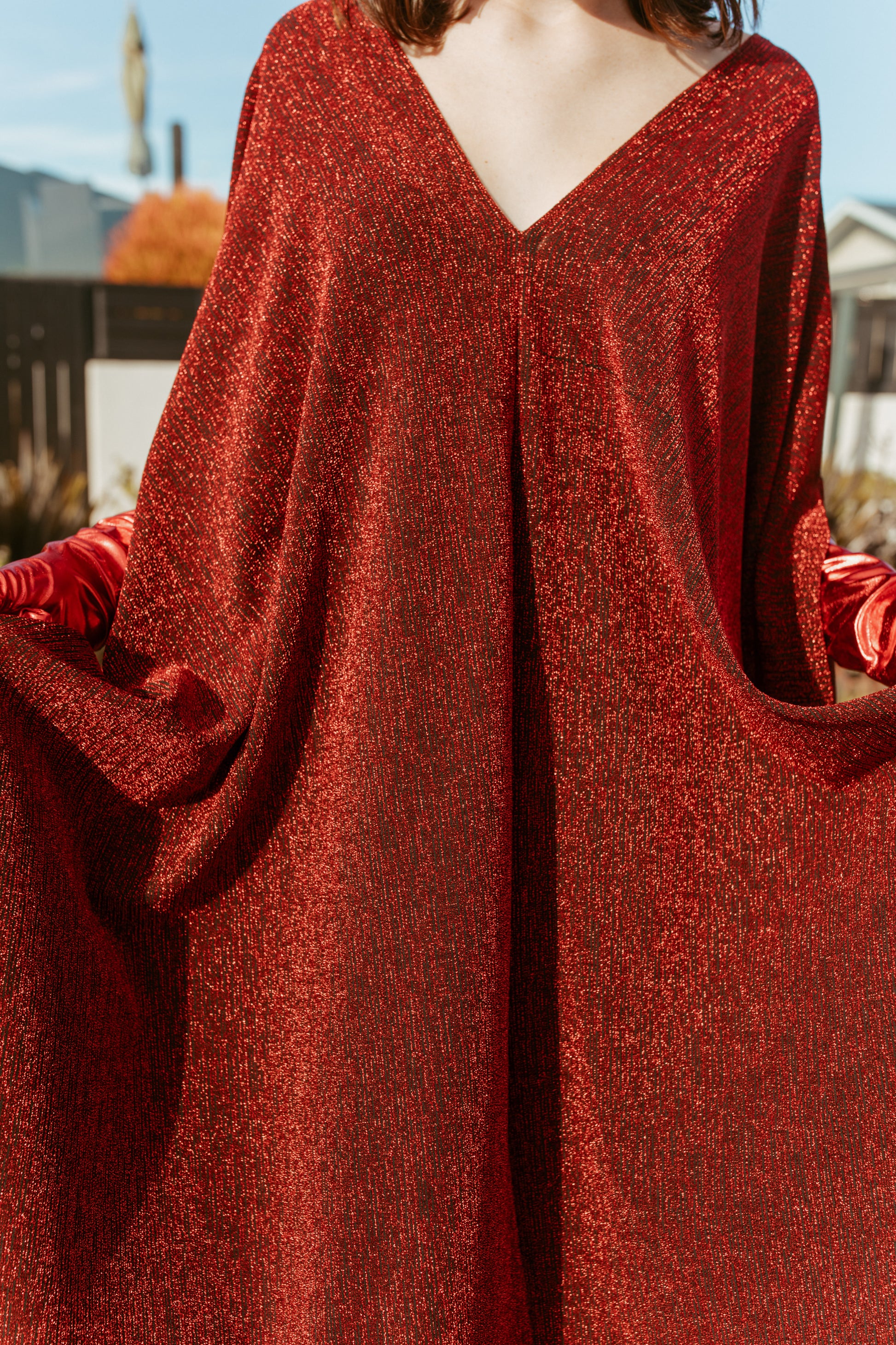 Shimmering, metallic crimson red caftan dress featuring v-neck at front and back.