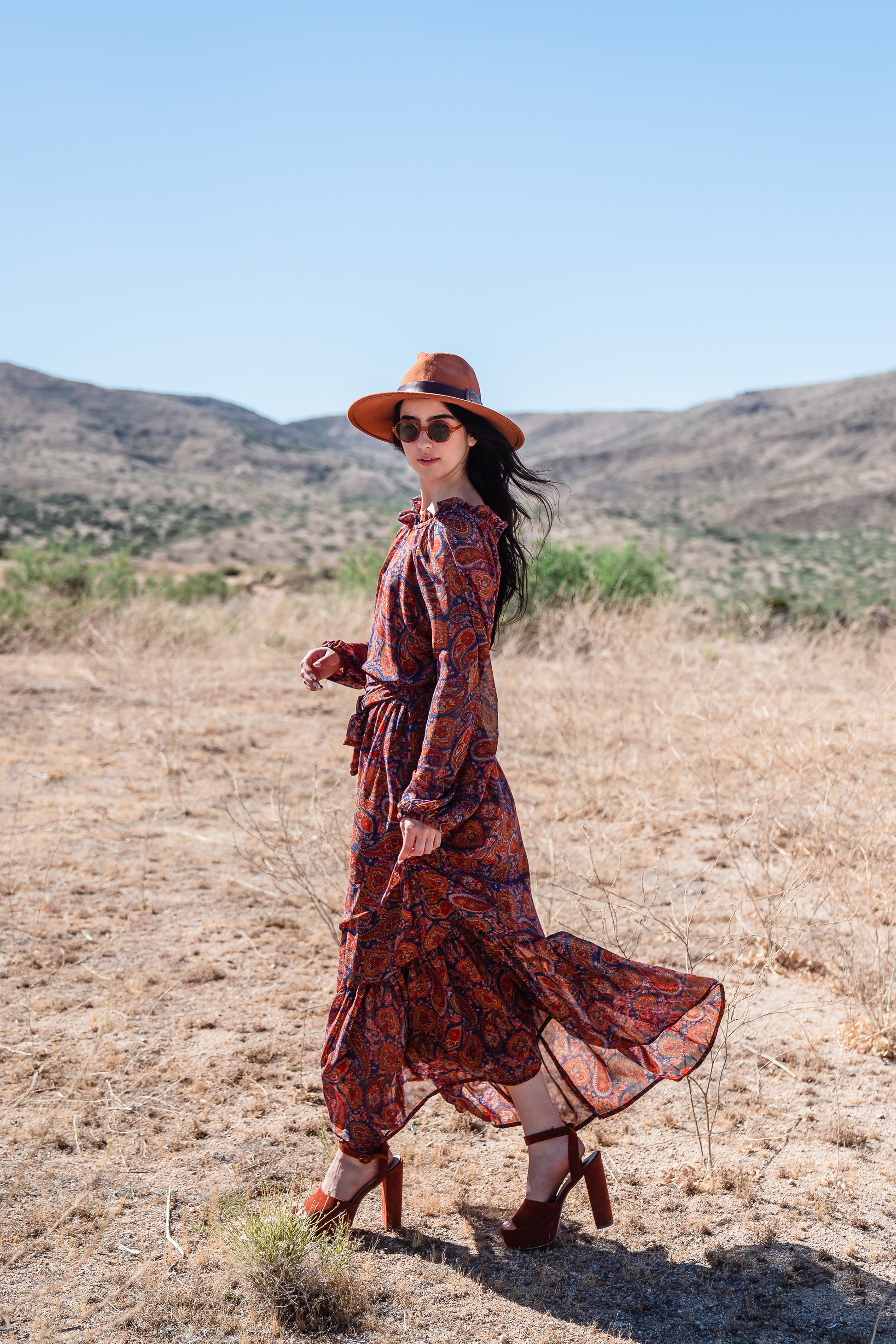 This ruffle collar, Paisley print, boho maxi dress features a soft cross ruffle skirt, blouson sleeve and hook and eye at back.