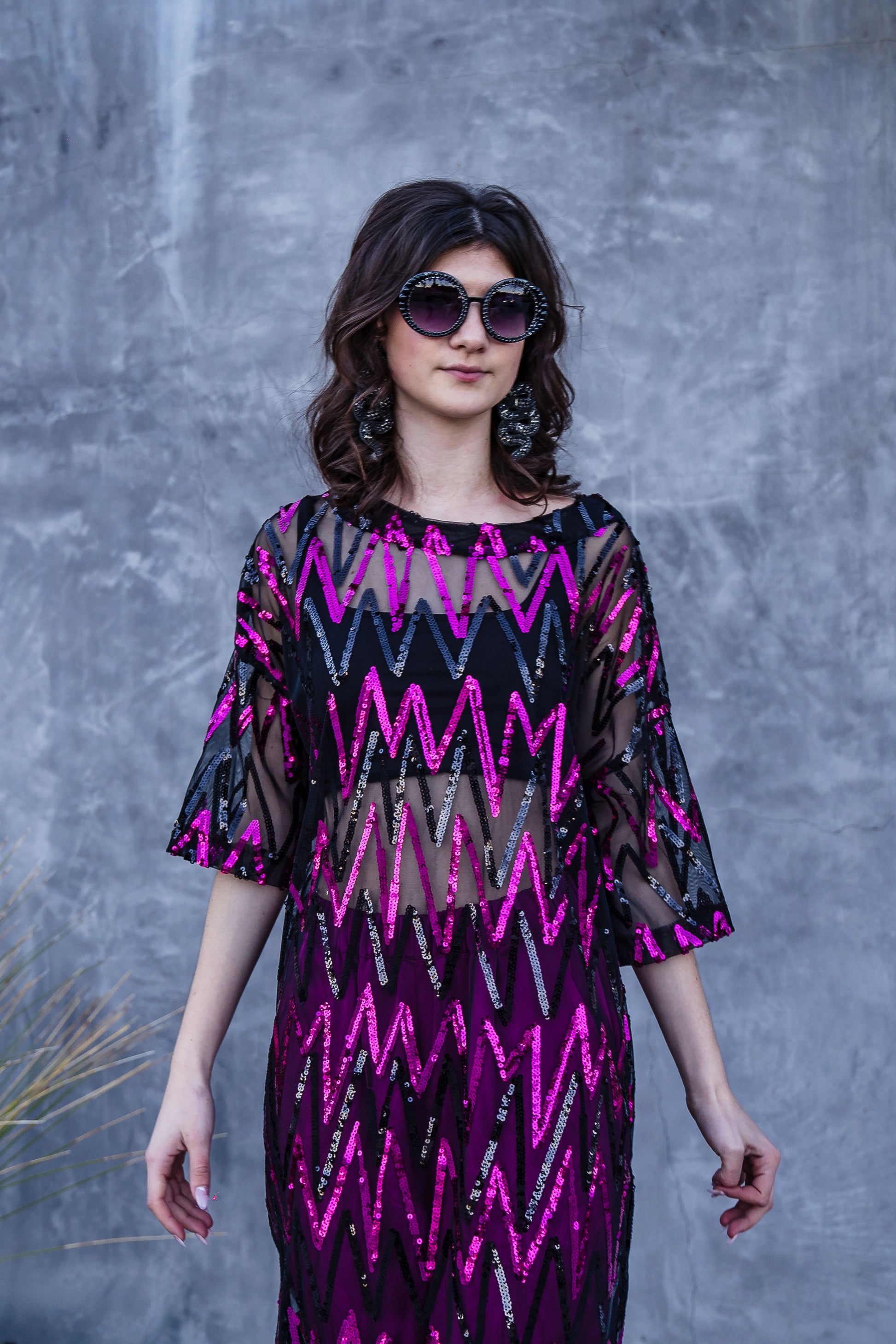 Studio Shimmer Side Split Tunic. This full length tunic is made from soft mesh fabric with sequin embellishments. The sequins alternate between fuschia and black zig-zag horizontal stripes. Light, floaty, and slinky it features a back keyhole closure, ankle length hem, mid-length sleeve, and knee length slits on both sides.