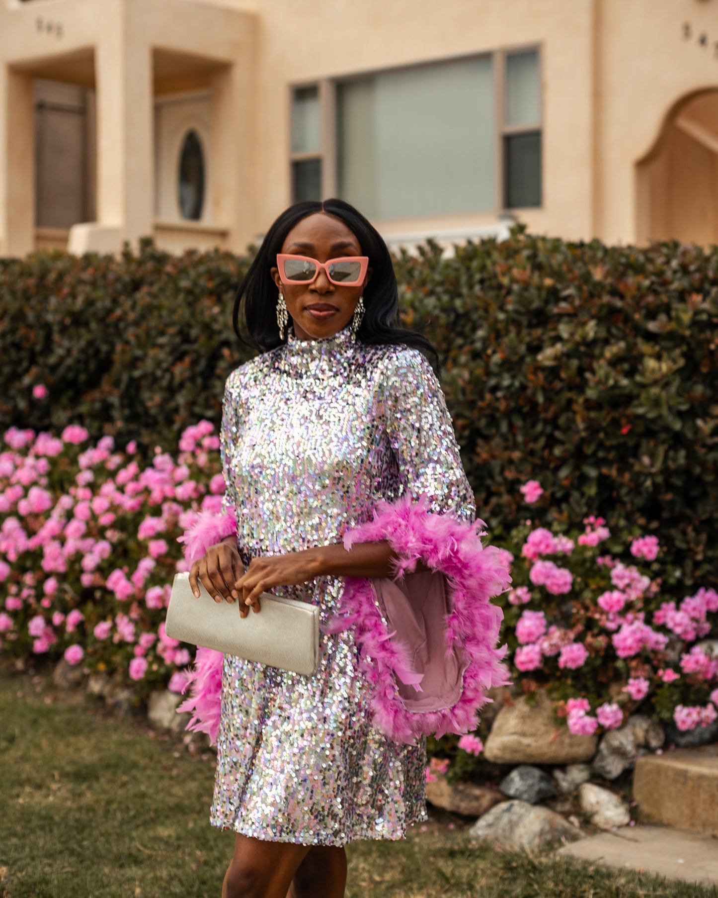 Glittery pastel sequins mock neck midi dress. Featuring long bell sleeves cuffed with rich pink feathers. The back features multiple closures to expose your back or hide bra straps as needed. May also be reversed and worn as a plunging deep-v neckline. Dress hem is just above knee.