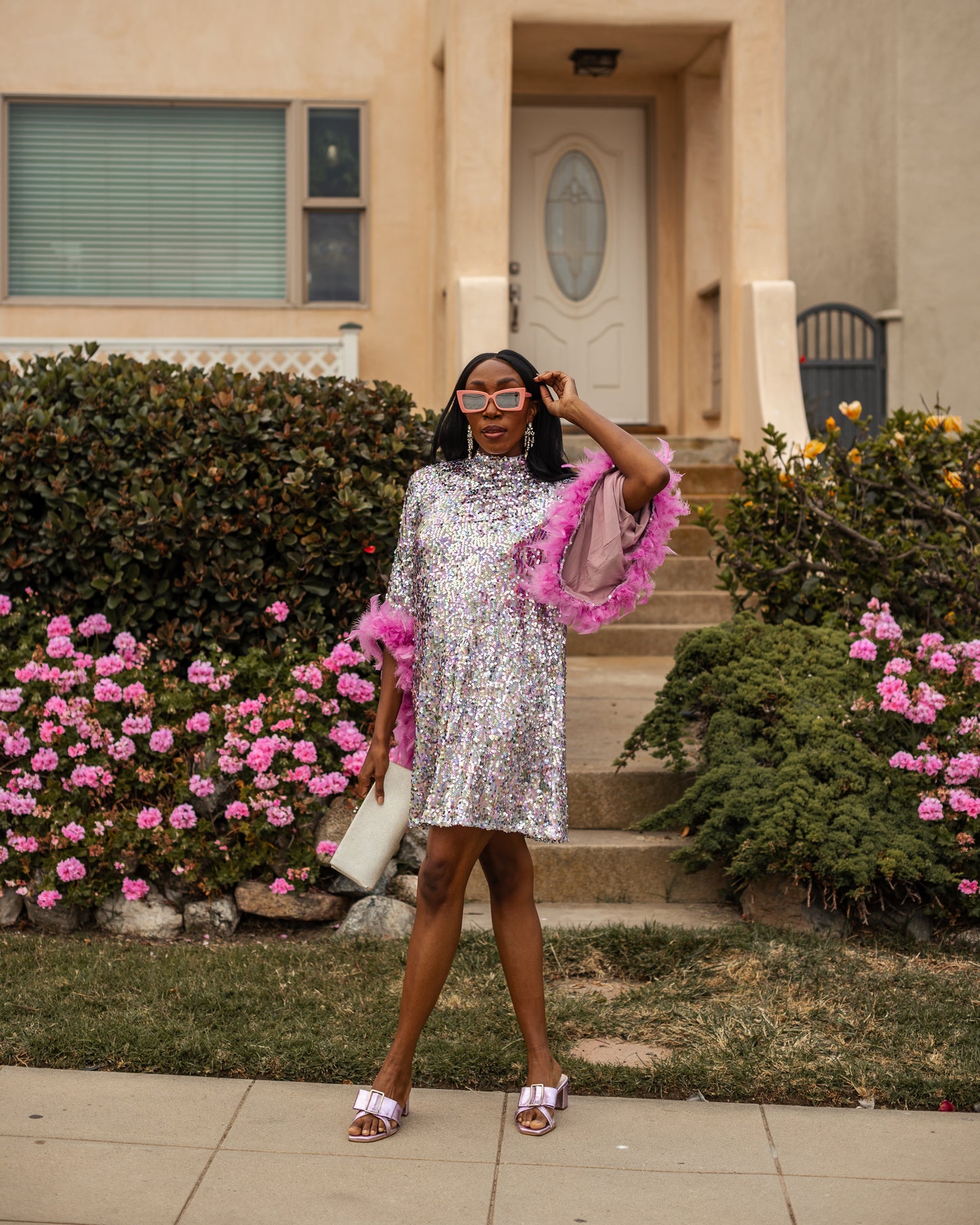 Glittery pastel sequins mock neck midi dress. Featuring long bell sleeves cuffed with rich pink feathers. The back features multiple closures to expose your back or hide bra straps as needed. May also be reversed and worn as a plunging deep-v neckline. Dress hem is just above knee.