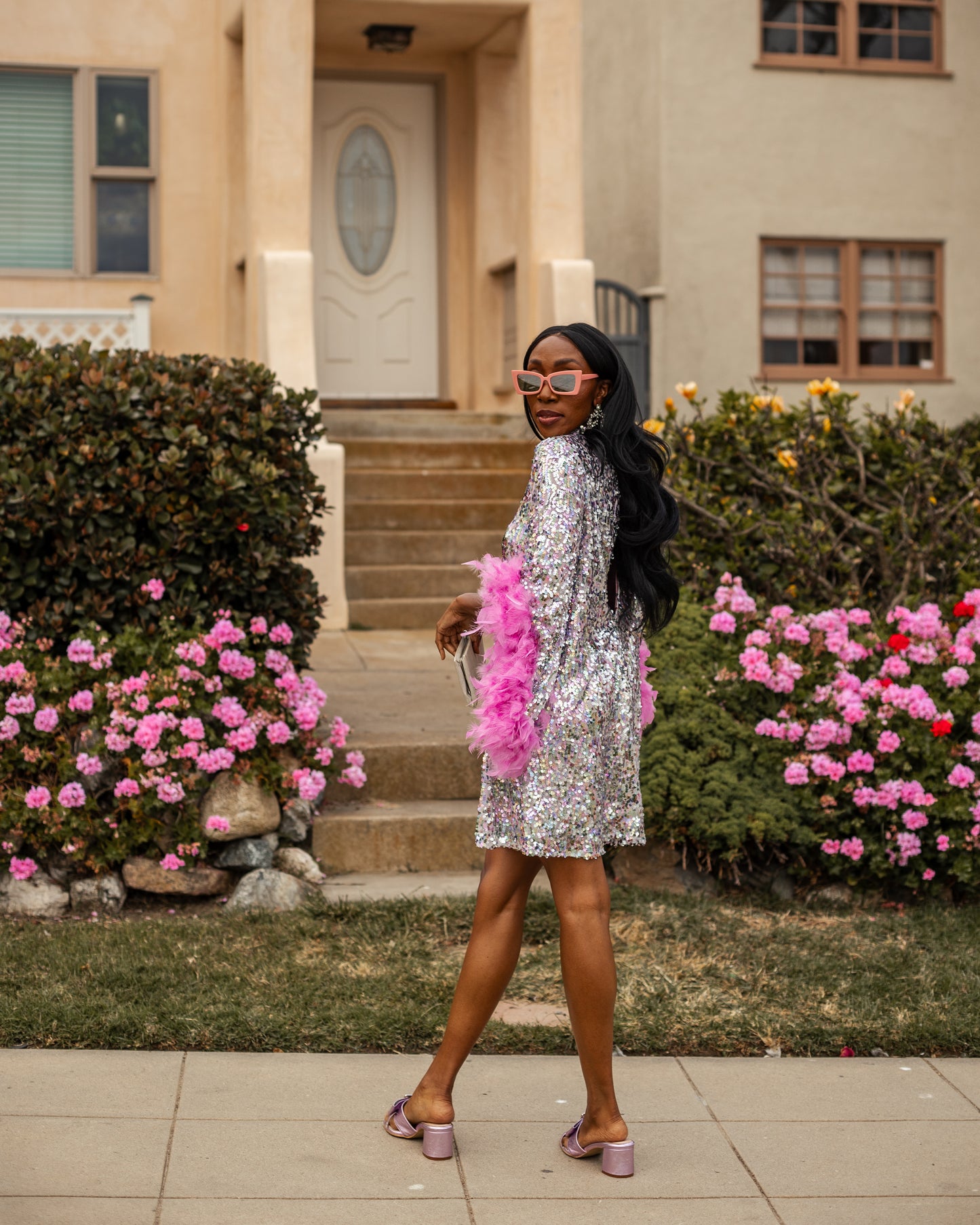 Glittery pastel sequins mock neck midi dress. Featuring long bell sleeves cuffed with rich pink feathers. The back features multiple closures to expose your back or hide bra straps as needed. May also be reversed and worn as a plunging deep-v neckline. Dress hem is just above knee.