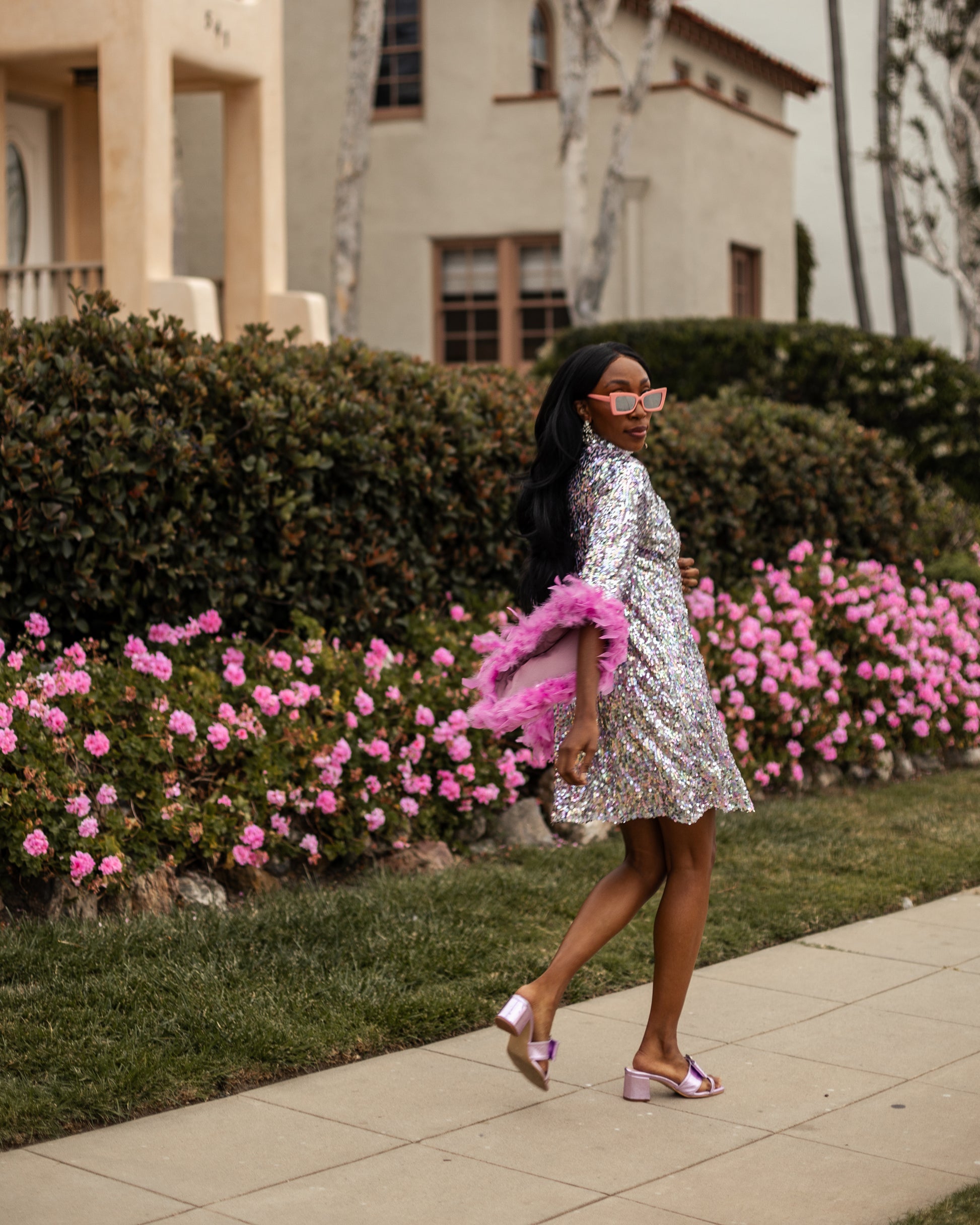 Glittery pastel sequins mock neck midi dress. Featuring long bell sleeves cuffed with rich pink feathers. The back features multiple closures to expose your back or hide bra straps as needed. May also be reversed and worn as a plunging deep-v neckline. Dress hem is just above knee.