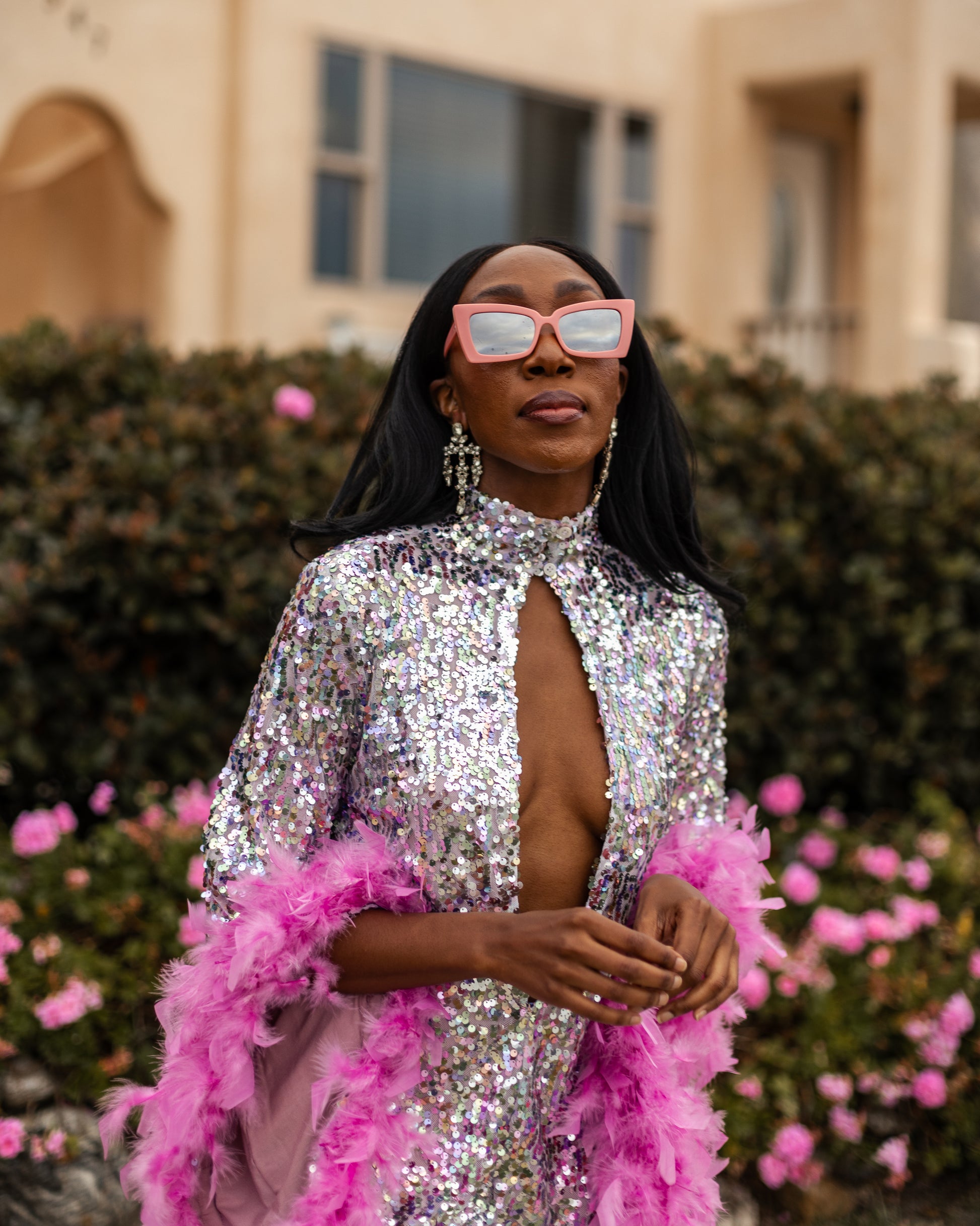 Glittery pastel sequins mock neck midi dress. Featuring long bell sleeves cuffed with rich pink feathers. The back features multiple closures to expose your back or hide bra straps as needed. May also be reversed and worn as a plunging deep-v neckline. Dress hem is just above knee.