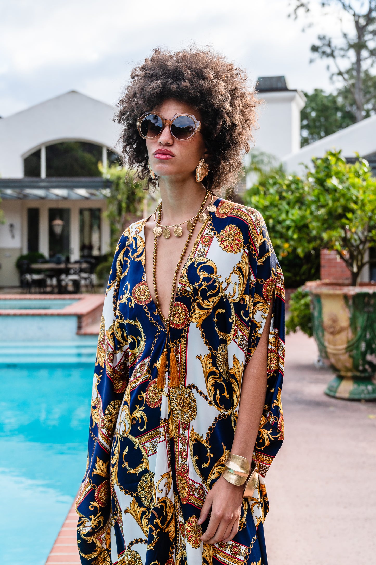 Jennafer Grace Voglia Nautica Caftan. Featuring a rococo baroque print with blocks of navy blue and white with golden and red accents. Featuring a deep v-neck, batwing sleeves, and an ankle length hem.