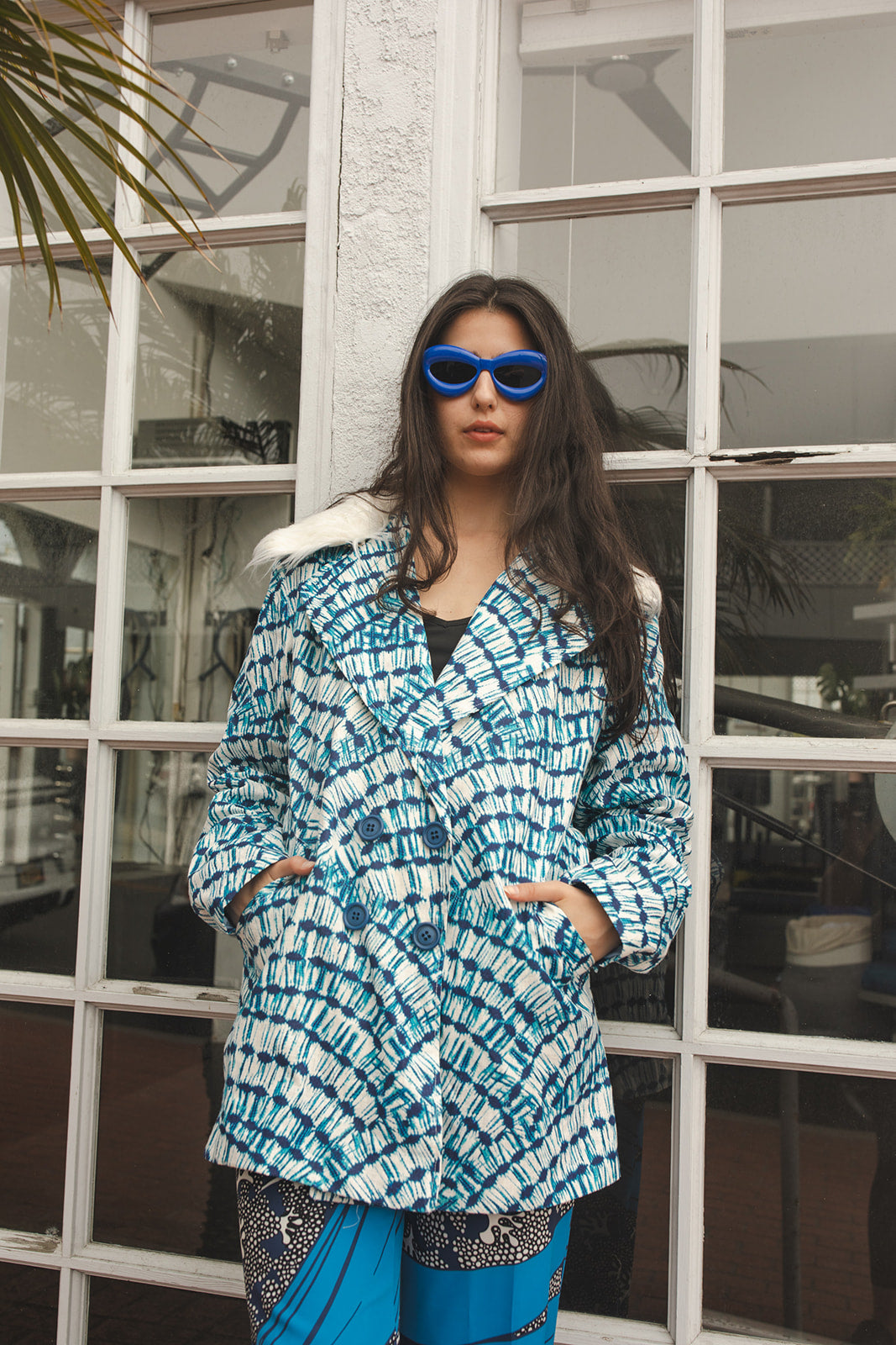 Boasting a striking aquarian color scheme on hand printed african fabric, this stylish piece is lined with a lush blue jersey and features a removable faux fur collar. 