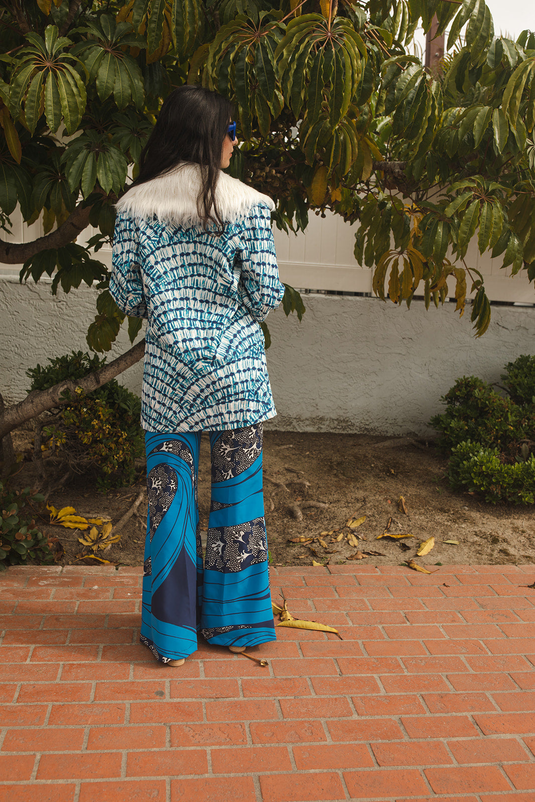 Boasting a striking aquarian color scheme on hand printed african fabric, this stylish piece is lined with a lush blue jersey and features a removable faux fur collar. 