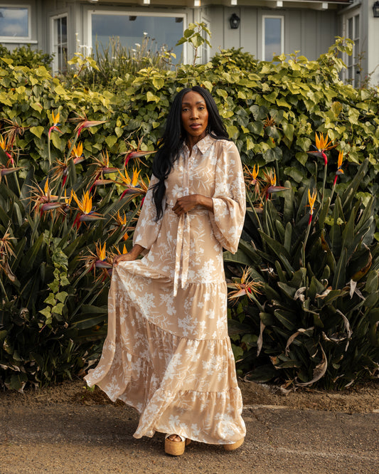 This floating chiffon maxi dress is sophisticated yet effortless with its high collar, button-up design paired with bishop sleeves, tiered skirt, and a slim matching sash. 