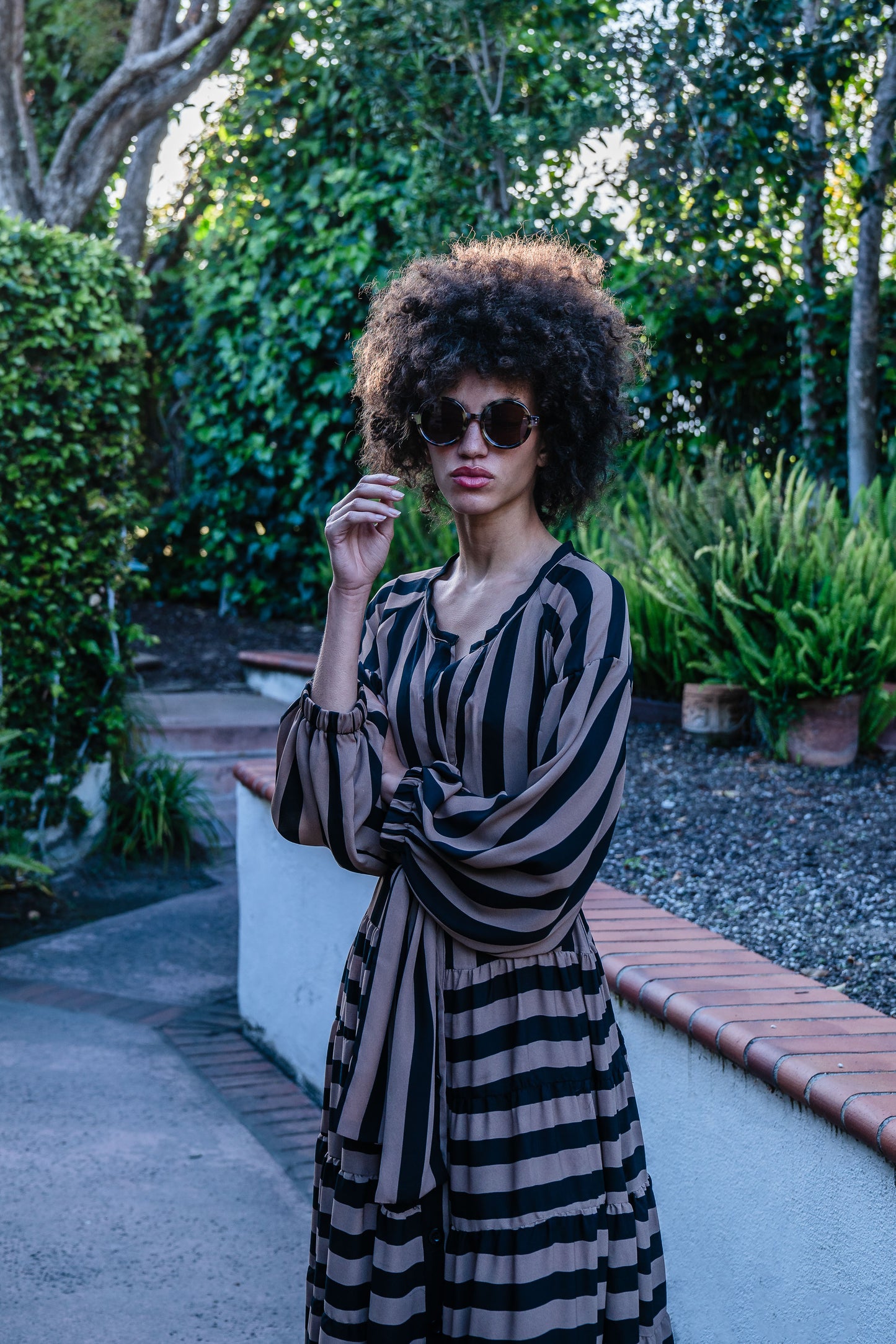 A coffee colored striped ruffled maxi dress. Featuring thick black and brown café stripes, long sleeves, ankle hem, full length button down in front, and optional belt to cinch the waist. 