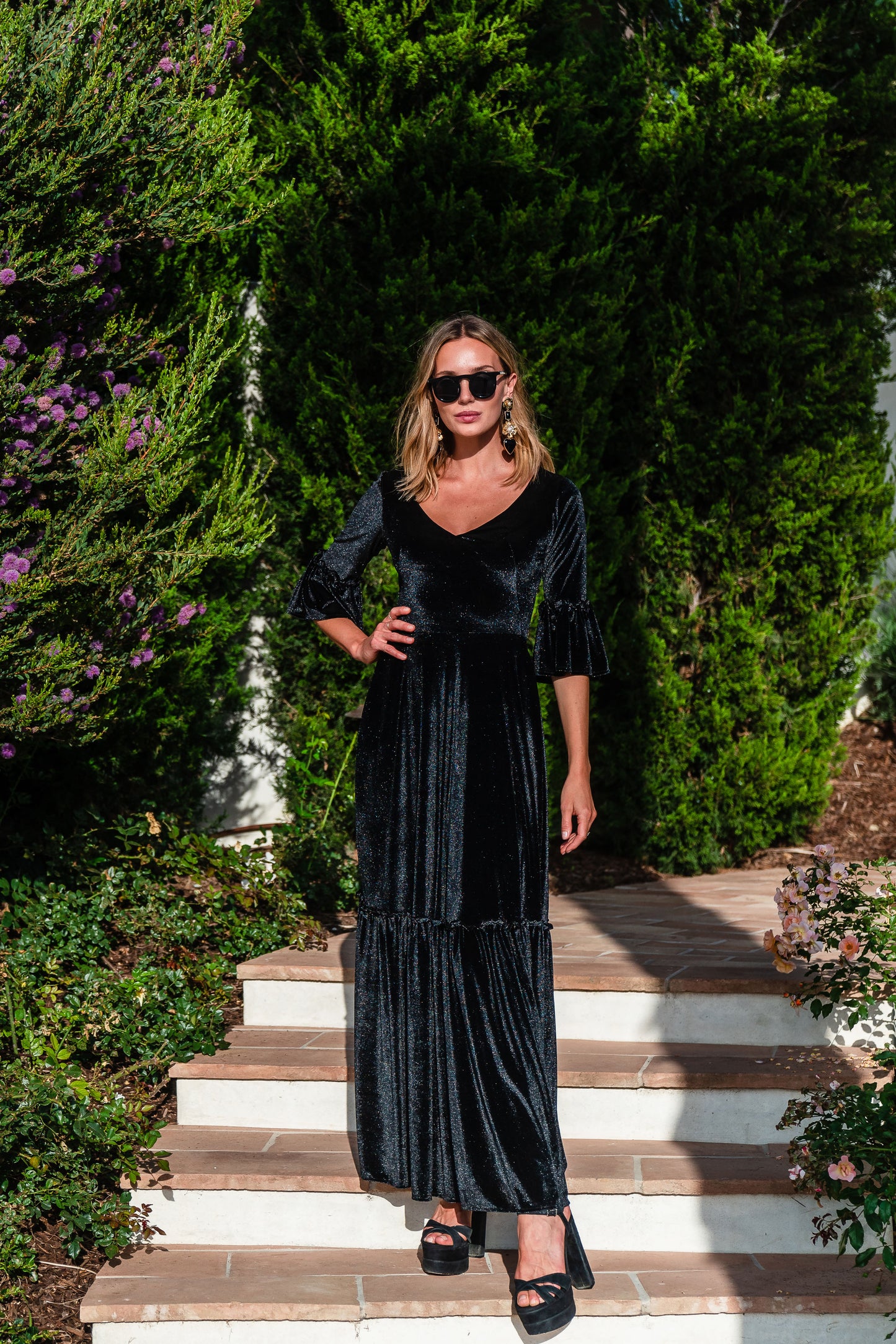 Shimmery black maxi dress with ruffle skirt and ruffled half sleeves. Featuring v-neck frontn and heart-shaped cutout in back, this dark dress is a gothic dream.