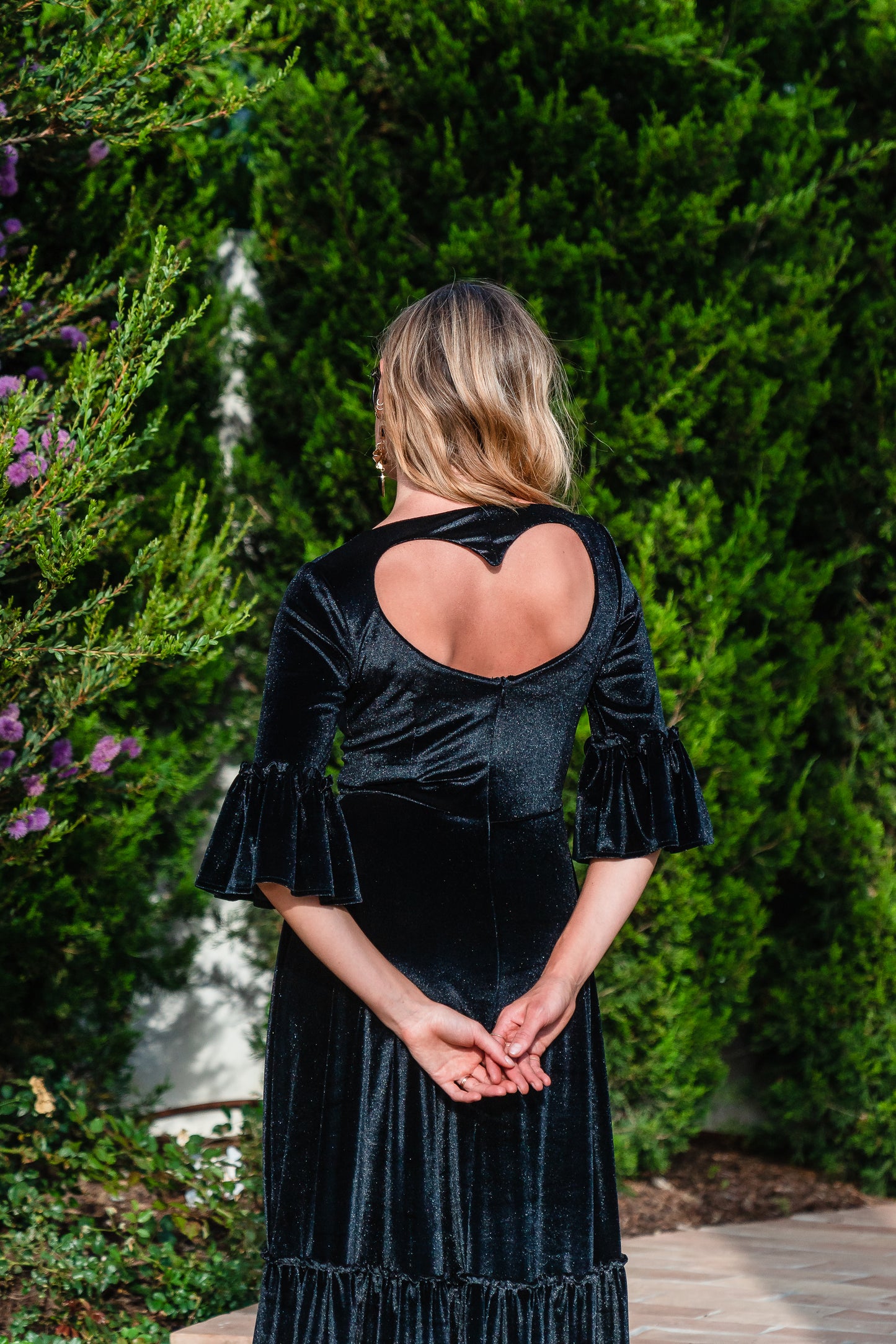 Shimmery black maxi dress with ruffle skirt and ruffled half sleeves. Featuring v-neck frontn and heart-shaped cutout in back, this dark dress is a gothic dream.