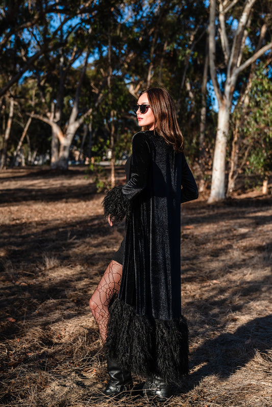  A black velvet faux fur cuff coat crafted from black stretch velvet, faux Alpaca fur cuffs at sleeve and hem, in-seam pockets, and black bamboo jersey lining.