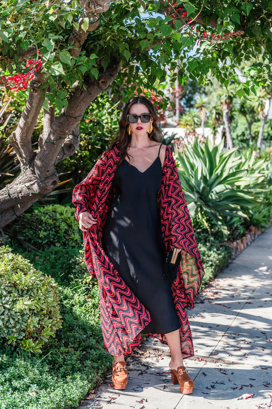  This Kimono features a futuristic spiral print in striking black and red, with a pop of orange for a modern and elegant touch. 