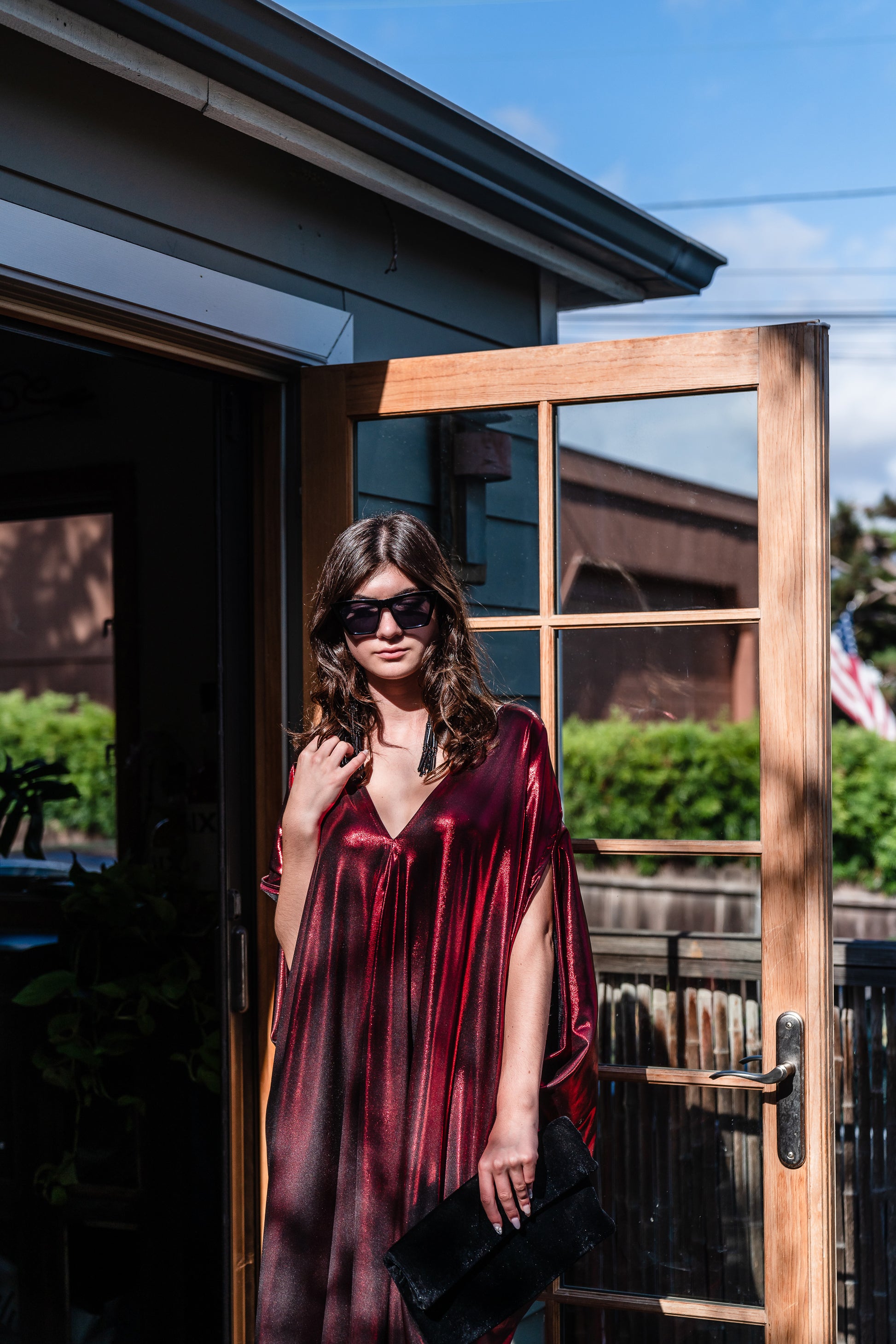 A metallic solid red caftan featuring batwing sleeves, a deep v neckline, and ankle length hem. 