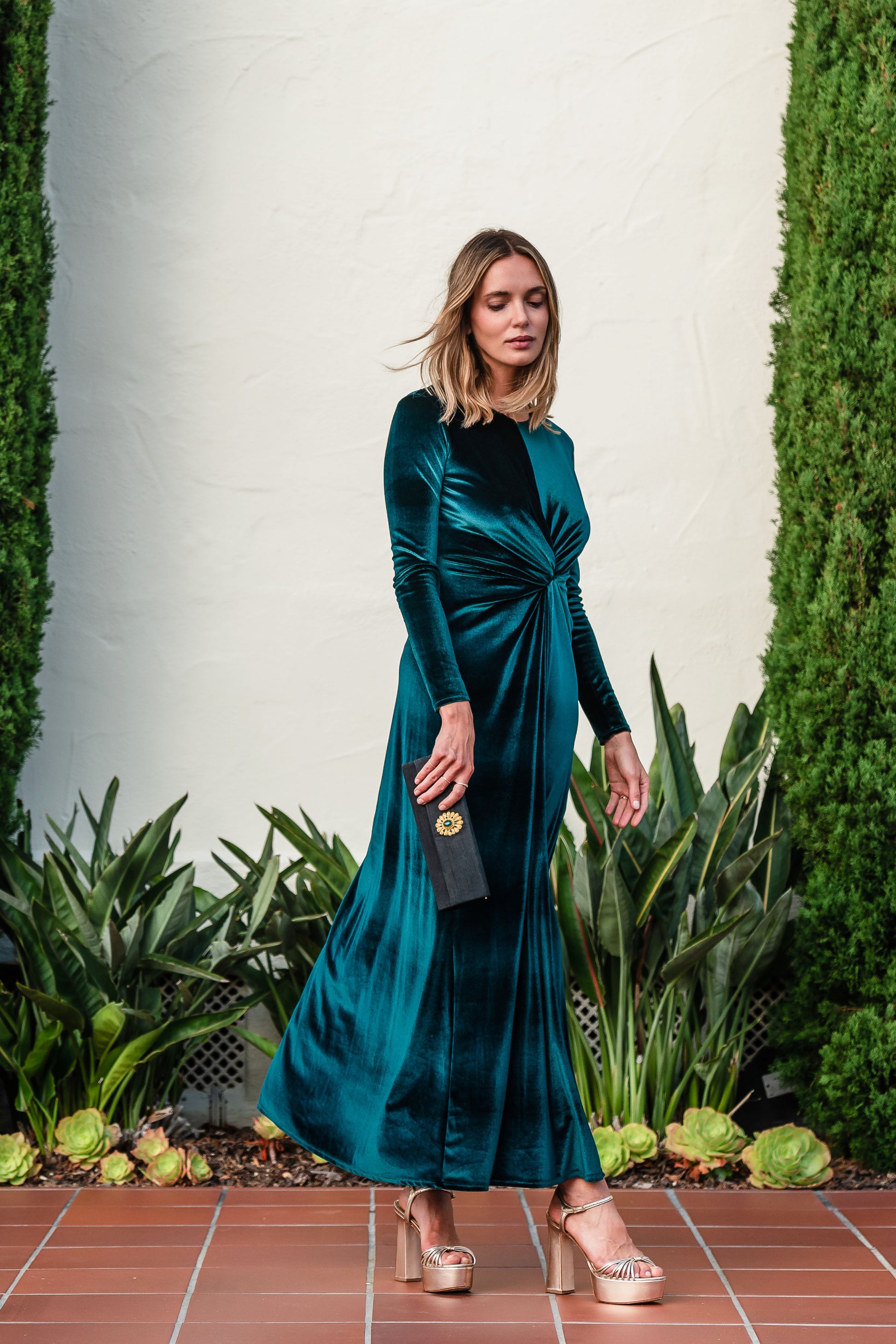 A stunning floor-length emerald velvet dress with long sleeves, elastic and a flattering knot detail at the waist.