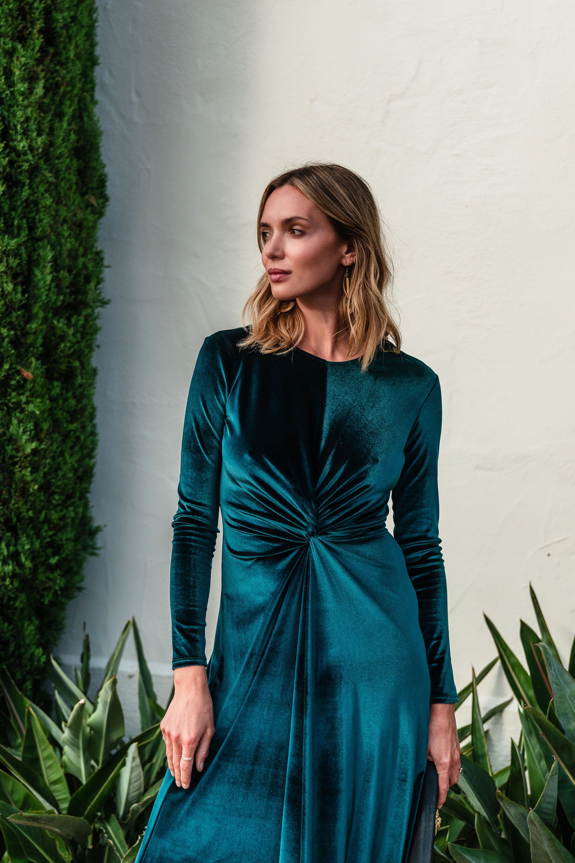 A stunning floor-length emerald velvet dress with long sleeves, elastic and a flattering knot detail at the waist.