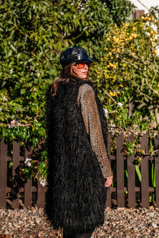 Model wears knee length, black, faux Mongolian lamb fur vest!