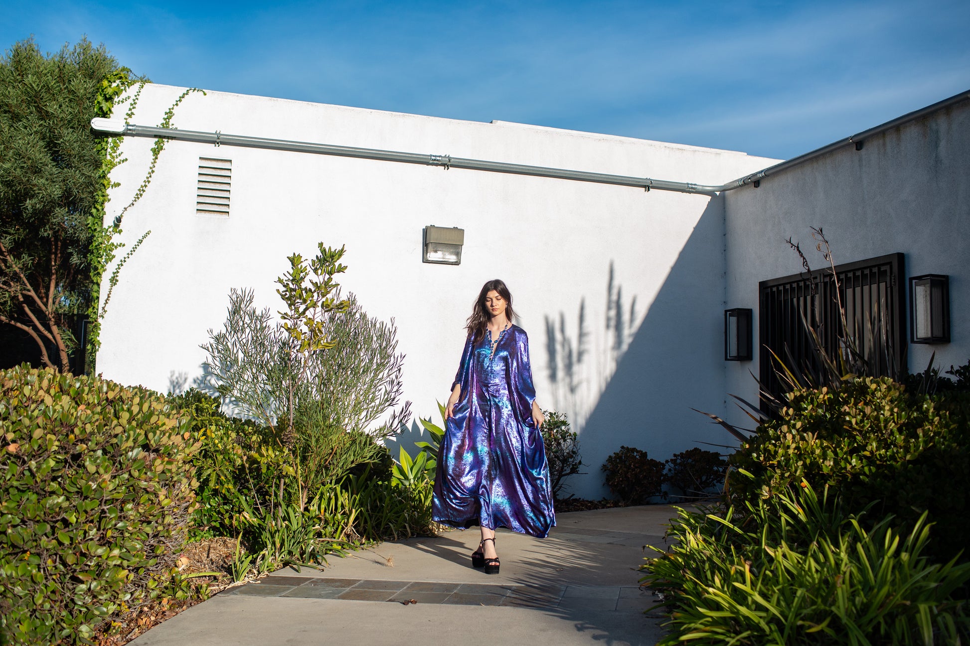 A shimmering Micro Velvet in rich amethyst tones. This new shape includes an attached waist tie to add new ways of wearing our classic caftan shape.