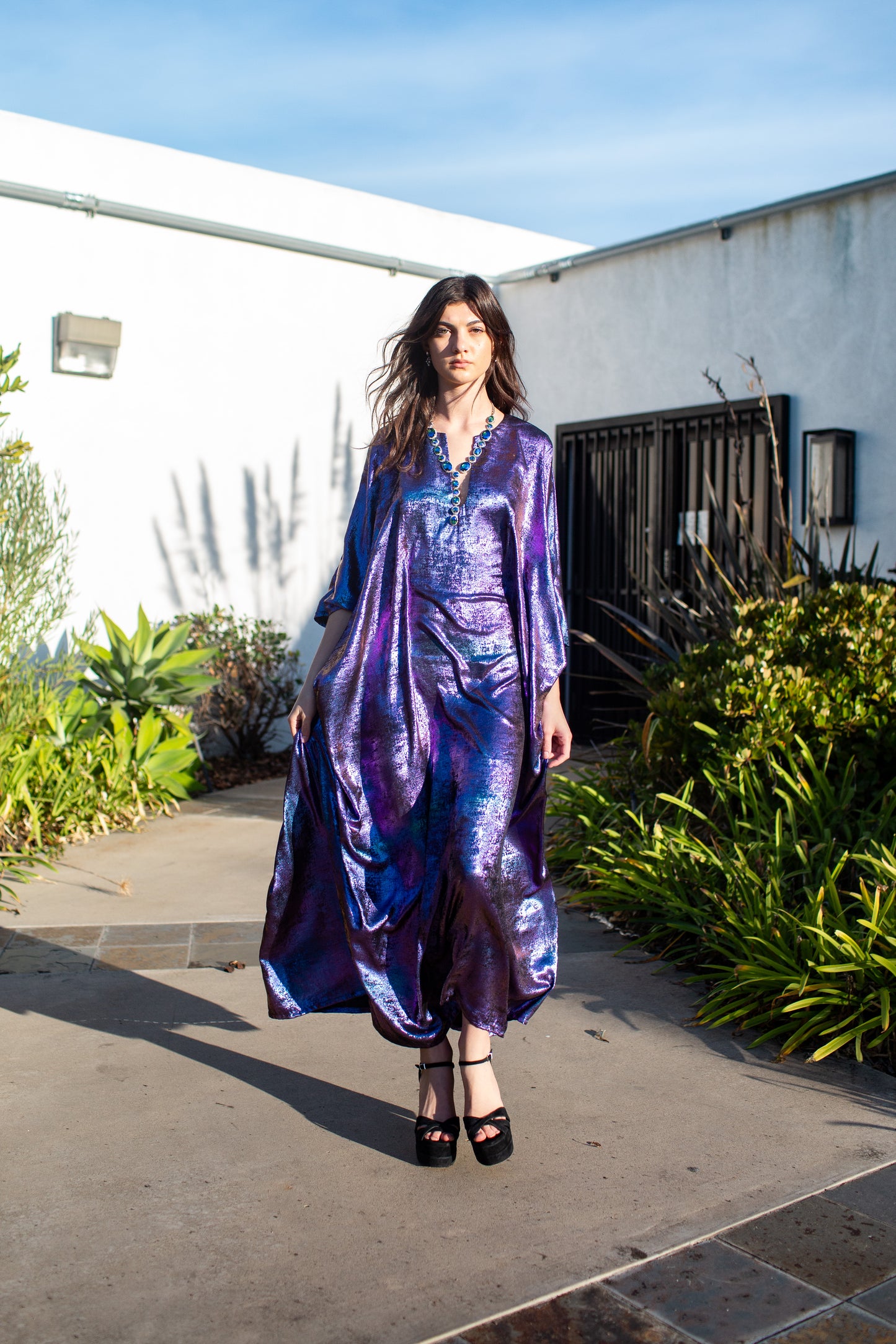 A shimmering Micro Velvet in rich amethyst tones. This new shape includes an attached waist tie to add new ways of wearing our classic caftan shape.