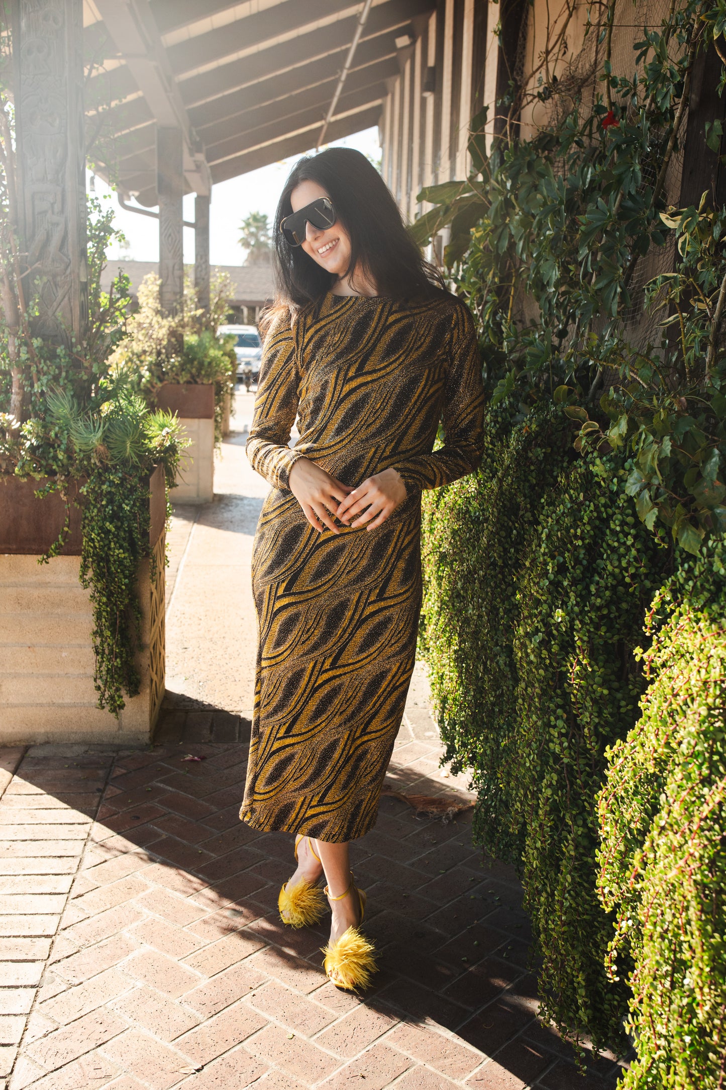 This pop-art bodycon dress accentuates your curves, while the removable feather trim on the sleeves adds a touch of elegance. The yellow cuffs and black and yellow fabric are perfect for those who shine bright.