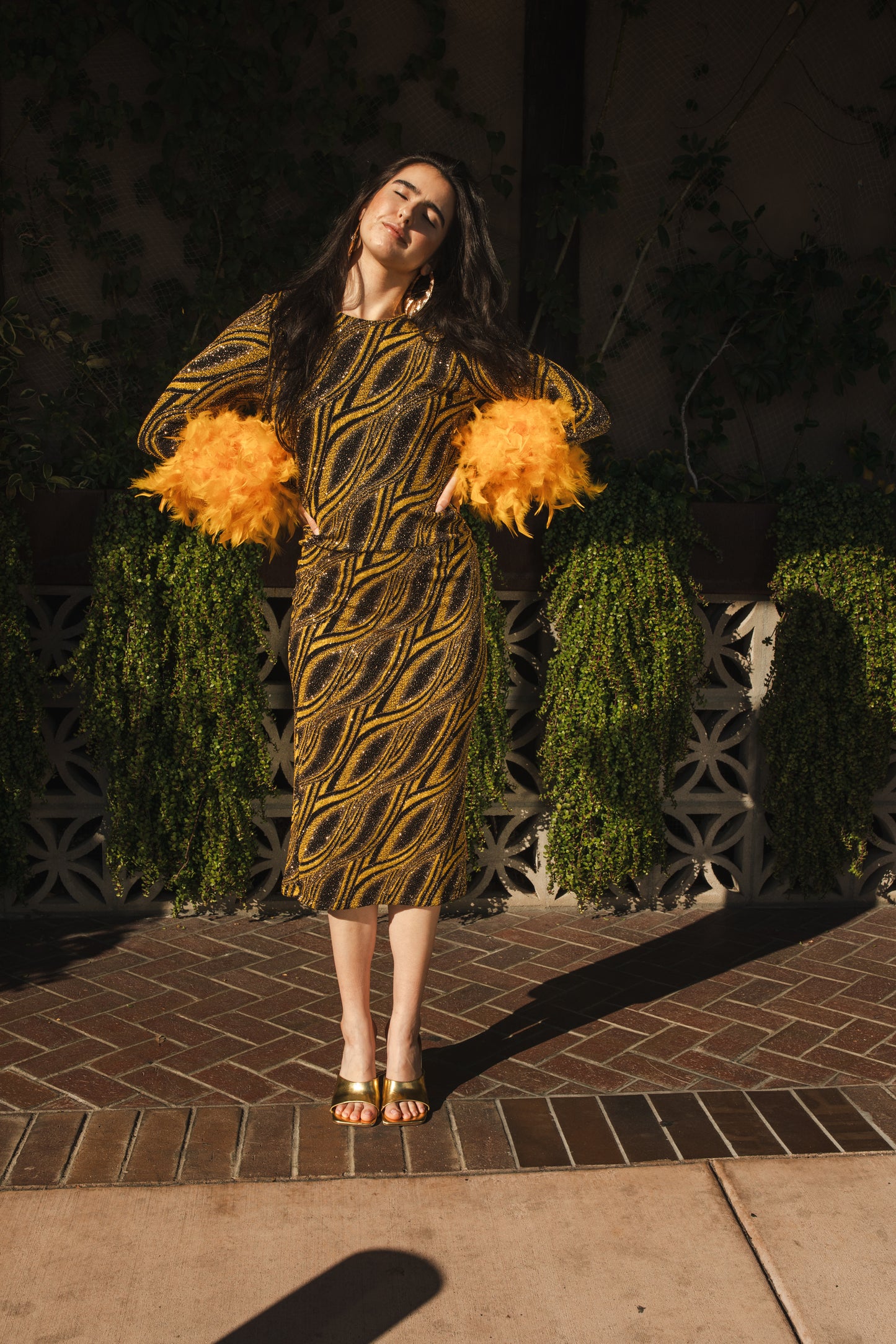 This pop-art bodycon dress accentuates your curves, while the removable feather trim on the sleeves adds a touch of elegance. The yellow cuffs and black and yellow fabric are perfect for those who shine bright.