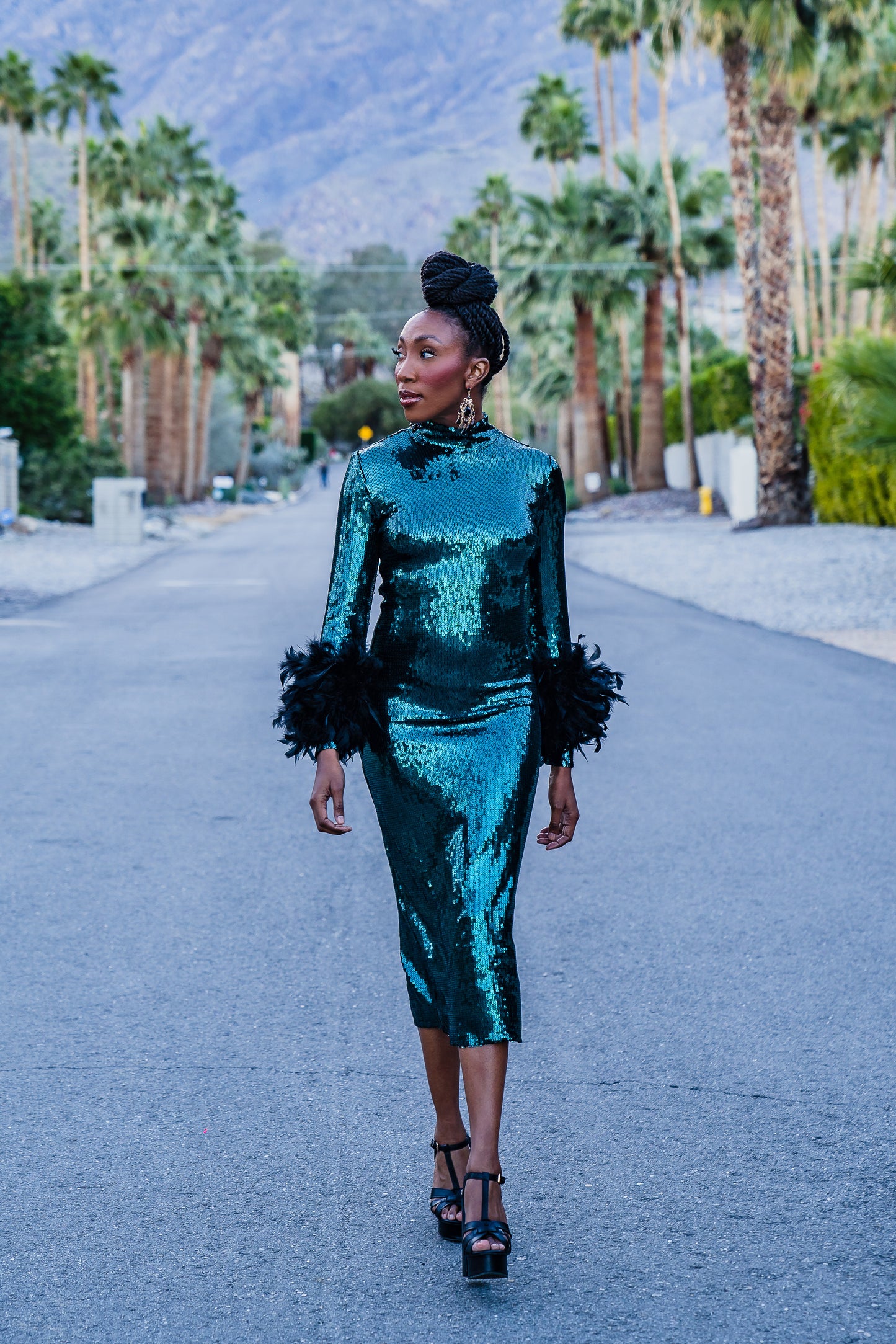 The emerald sequined, bodycon design accentuates your curves, while the removable feather trim on the sleeves adds a touch of elegance.