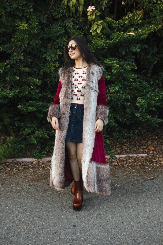 This luxe burgundy stretch-velvet coat features fur cuffs at sleeve and hem with in-seam pocket.