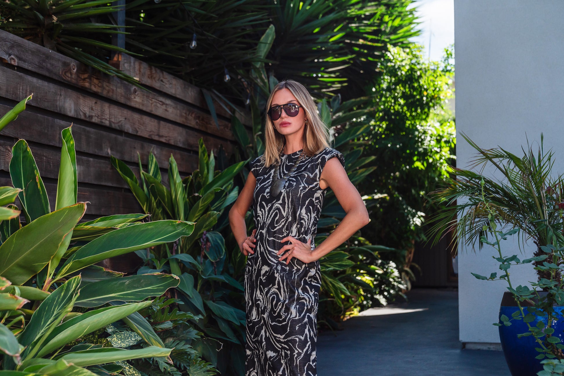 Knee length sleeveless shift dress, in a black and taupe abstract, marble like pattern, the dress has shoulder pads.

