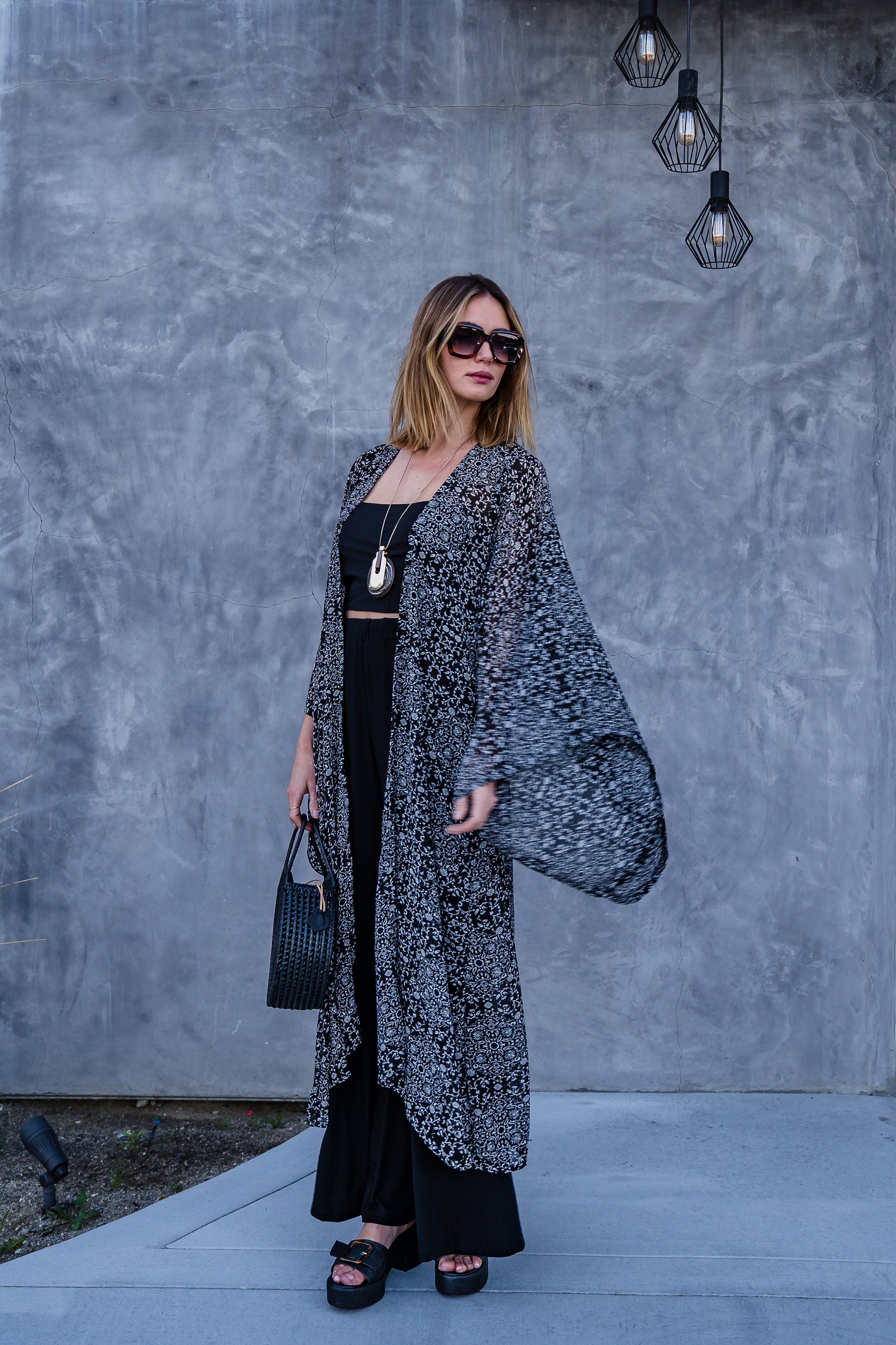 Long sleeve kimono with ankle length hem is made from a soft semi-sheer rayon chiffon. Featuring a black and white victorian floral pattern. It also features pockets, deep v-neck when tied shut, and a matching waist tie-you can style this piece in at least 10 ways.