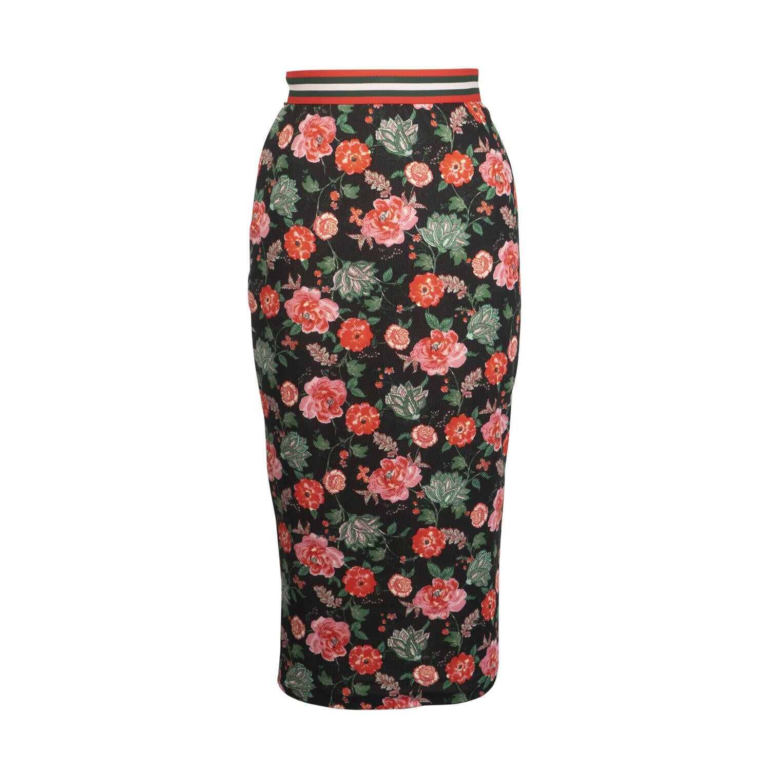 Black midi pencil skirt with floral print featuring shades of pink, red, and green. The waist is accented with a thick, red, green, and white striped elastic waistband and the hem sits below the knee in length. Bold vintage inspired romantic bohemian style.